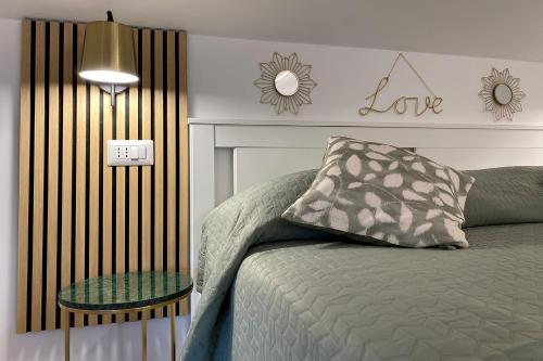 a bedroom with a bed and a love sign on the wall at La Piazzetta 194 in Fregene