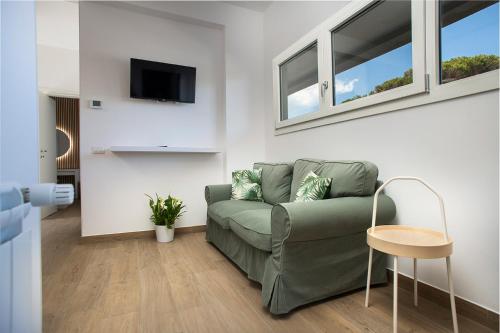 a living room with a green couch and windows at La Piazzetta 194 in Fregene