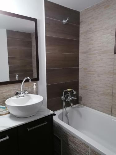 a bathroom with a sink and a bath tub at The Host - Women and couples only in Paphos City