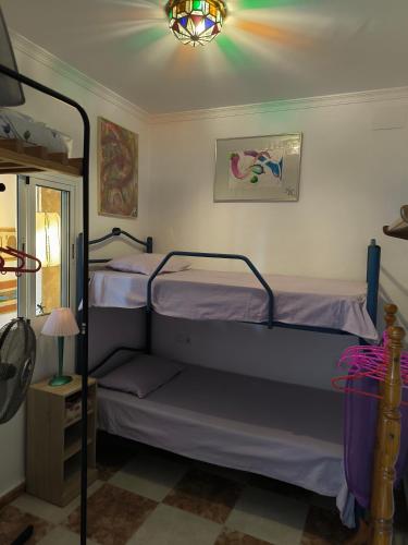 a bedroom with two bunk beds and a chandelier at Villa Coral in Chiclana de la Frontera