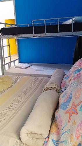 a bunk bed in a room with a blue wall at Soul do Mar Hostel in Cabo Frio