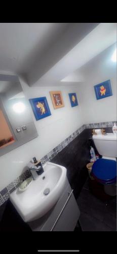 La salle de bains est pourvue d'un lavabo, de toilettes et de photos murales. dans l'établissement Hamdi, à Ivry-sur-Seine