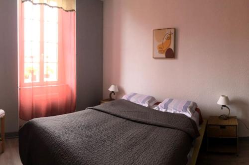 une chambre avec un lit et une fenêtre dans l'établissement Maison de caractère au village, à Pontenx-les-Forges