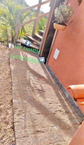 a dirt path next to a building with a plant at Casa 422 - Loft Jasmim in Santana do Riacho