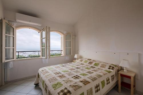 une chambre blanche avec un lit et deux fenêtres dans l'établissement Résidence le Hameau de Cap Esterel - maeva Home - Maison 3 pièces 6 personnes - Prestige MAE-2101, à Saint-Raphaël