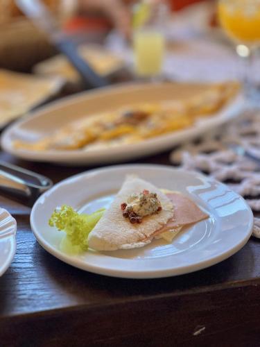 a white plate with a piece of food on a table at Casarao da Terra in Prado