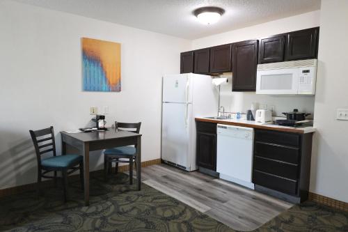 a small kitchen with a table and a refrigerator at MainStay Suites Madison Airport in Madison