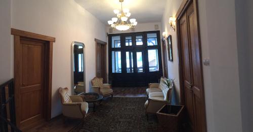 a hallway with chairs and a chandelier at IL Piccolo Castello Busteni in Buşteni
