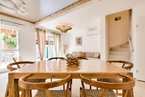 une salle à manger avec une table et des chaises en bois dans l'établissement Maison route du lion - maeva Home - Maison avec jardin 3 pièces 4 personnes proche plage - Exclusive - super Home MAE-5831, à Lacanau