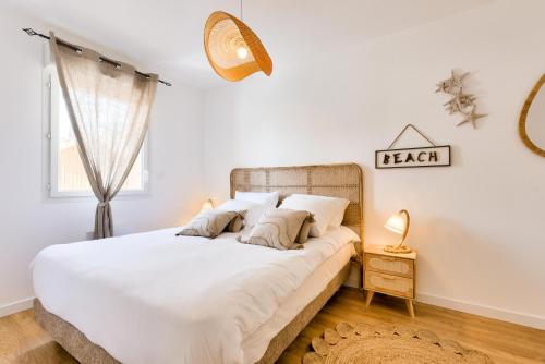 une chambre avec un lit avec des draps blancs et une fenêtre dans l'établissement Maison route du lion - maeva Home - Maison avec jardin 3 pièces 4 personnes proche plage - Exclusive - super Home MAE-5831, à Lacanau