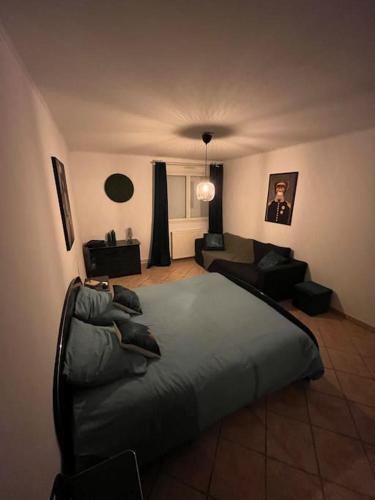 a bedroom with a large bed and a couch at Gîte de Beaufresne in Haudricourt