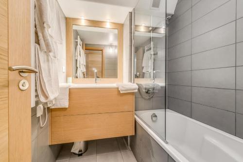 une salle de bain avec une baignoire, un lavabo et un miroir dans l'établissement Résidence Palafour - Studio cabine 4 personnes pieds des pistes - balcon vue Grande Sassière MAE-3629, à Tignes