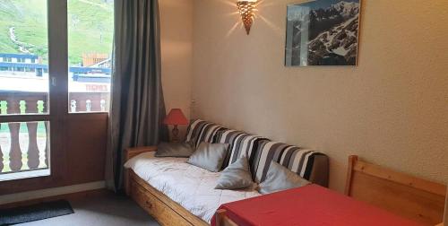 un lit dans une chambre avec une fenêtre dans l'établissement Résidence Rond Point Des Pistes - proximité immédiate des pistes et des remontées mécaniques (Funiculaire) MAE-3681, à Tignes