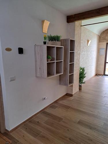 a room with white walls and wooden shelves with potted plants at Struttura Monte Olimpo in Porto Torres