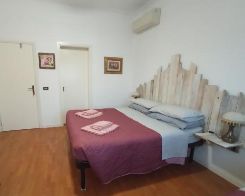 a bedroom with a large bed with a wooden headboard at Casa Vintago b&b in Savio di Ravenna