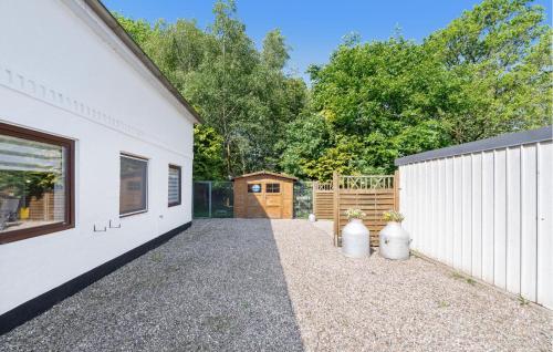 a white building with a gate and two vases at Am Moor in Achtrup