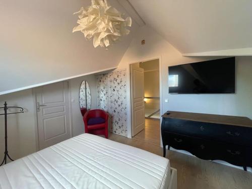 une chambre avec un lit et une télévision à écran plat dans l'établissement Spacieux appt familial - 3 chb - Parking - Wifi, à Arcachon