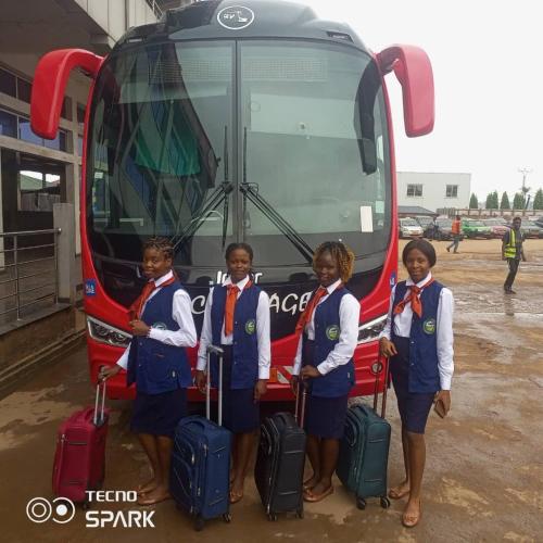 four girls standing in front of a bus with luggage at AFRIEUROTEXT Kamerun-High Standing-Appartements-Wifi-Security-Restaurant-modern Kitchen in Yaoundé