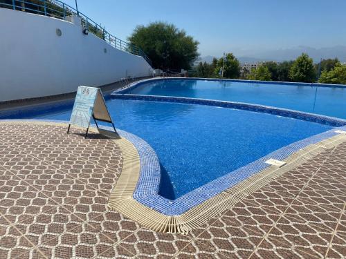 een zwembad met een bord naast een gebouw bij Apparemment Noura in Tetouan