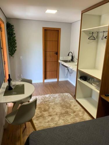 a room with a kitchen with a table and a mirror at Microcasa na cobertura in Santa Teresa