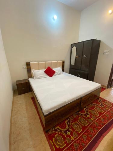 a bedroom with a bed with a red pillow on it at The Venetian 2bhk Entire Homestay in Rāja Sānsi