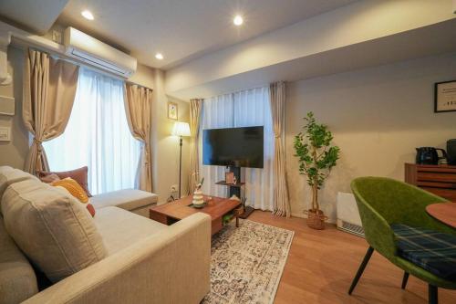 a living room with a couch and a flat screen tv at Brand New Open ROOM MD 401 Max 6pax in Sapporo