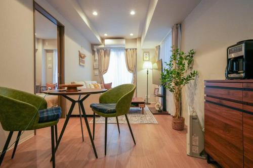 a living room with a table and two green chairs at Brand New Open ROOM MD 401 Max 6pax in Sapporo