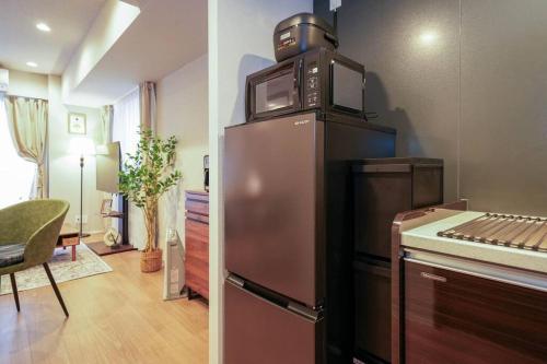 a kitchen with a microwave on top of a refrigerator at Brand New Open ROOM MD 401 Max 6pax in Sapporo