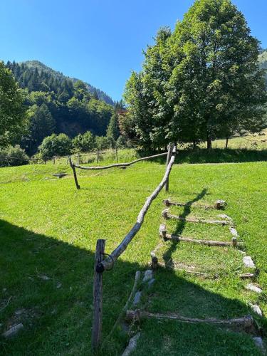 a wooden fence in a field with a tree at A cjase di Luca in Paluzza