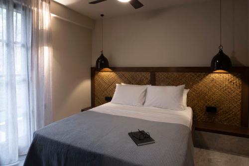 a bedroom with a bed with a book on it at RiZEΣ in Ouranoupoli