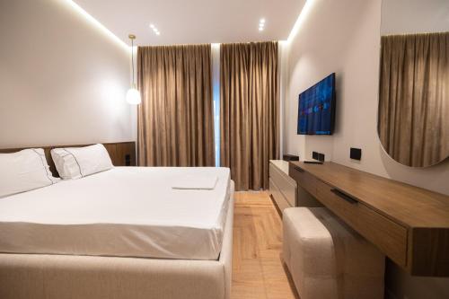 a hotel room with a bed and a desk at Diora'S Hotel and Apartments in Vlorë