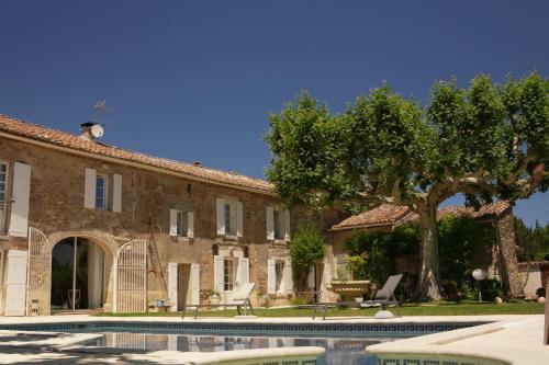 une maison avec piscine devant un immeuble dans l'établissement LE MAS DES FLANERAIES, à Althen-des-Paluds