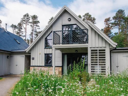 a white house with a balcony at Golden Eagle Lodge in Kingussie