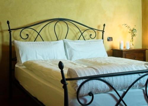 a bedroom with a bed with white sheets and pillows at Agritur Maso Carpenè in Rovereto