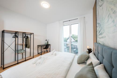 a bedroom with a white bed and a blue couch at koCASA-Apartments 02, Design, City-Center Böblingen, Stellplatz, Balkon in Böblingen