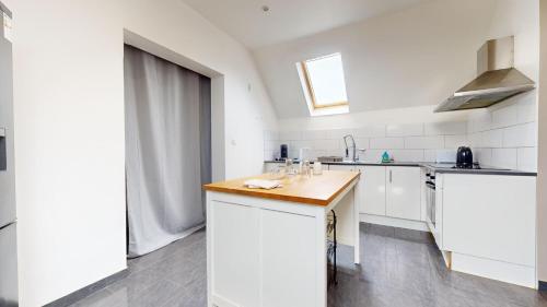 une cuisine avec des armoires blanches et un comptoir en bois dans l'établissement Le nid perché Mulhouse, à Mulhouse