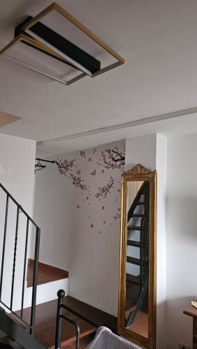a mirror on a wall next to a staircase with flowers on it at Casa Ruffo in Francavilla di Sicilia