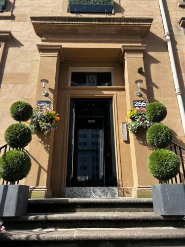a front door of a building with potted plants at Amani Apartments - Glasgow City Centre in Glasgow