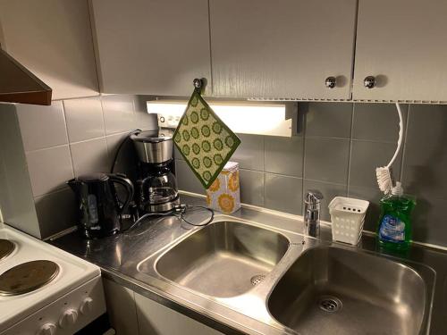 a kitchen counter with a sink and a stove at Saunallinen yksiö keskustassa in Pieksamaki