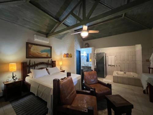 a bedroom with a bed and a bathroom with a tub at Pousada Cheiro da Terra in Cunha