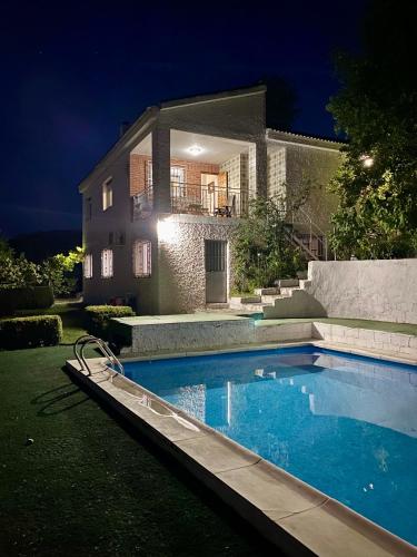 a swimming pool in front of a house at night at Casa rural Balcón de Monachil in Monachil