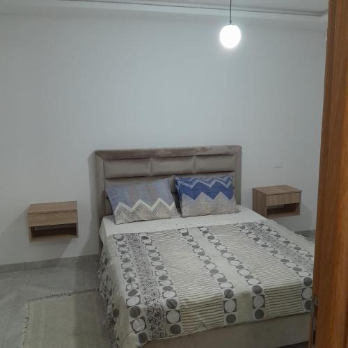 a bedroom with a bed with pillows on it at My studio in Al Matlīn