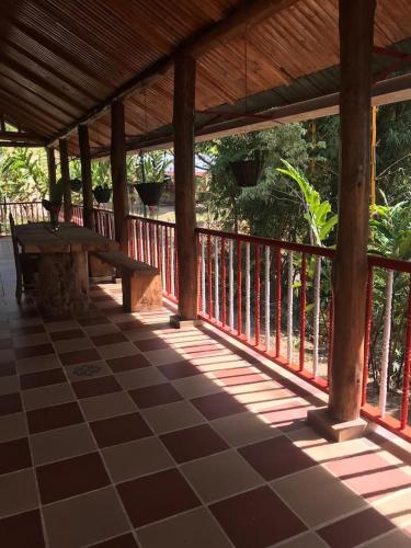 a porch with a bench on a wooden deck at Finca La Vistosa in Sasaima