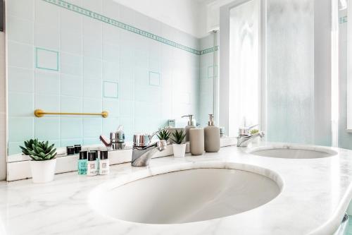a bathroom with a large white sink and a mirror at 'Nature Home' 30MT SEA -CENTRAL STATION -NETFLIX in Pietra Ligure