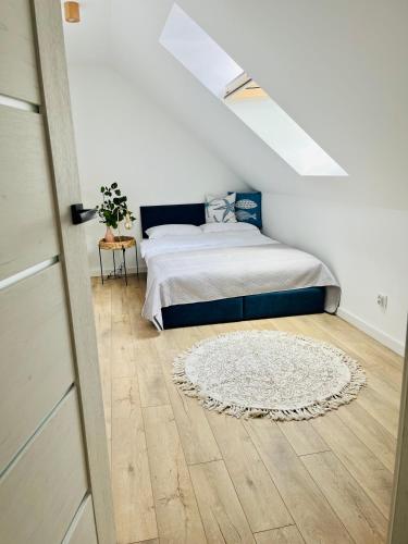 a bedroom with a bed and a white rug at Białogórskie wrzosowisko in Białogóra