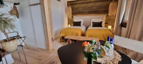 a bedroom with two beds and a table at La Villa Tonga - Chambres d'hôtes à Fronsac in Fronsac