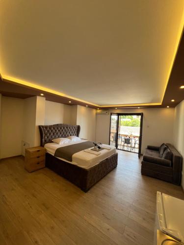a bedroom with a large bed and a chair at City Heart Apartments in Ulcinj