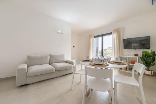 a living room with a couch and a table and chairs at Holiday Camelia in Pirri
