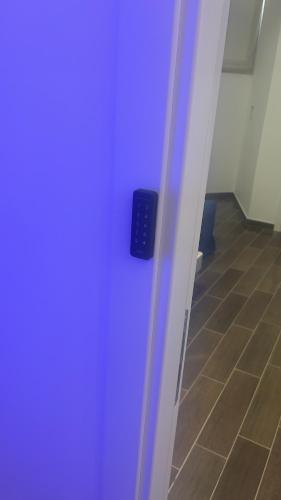 a blue door with a black object in a hallway at B&B Santorini in Scalea