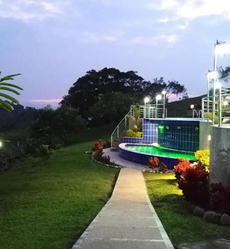 a walkway leading to a swimming pool at night at Finca La Vistosa in Sasaima